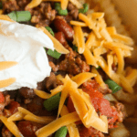 Fries covered with chili and cheese with a dollop of sour cream.