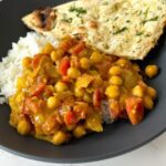 Coconut Chickpea Curry on top of white rice in a bowl.