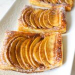 Golden brown apple puff pastry tarts with cinnamon sugar, fresh out of the oven.