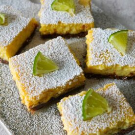 Margarita bars with powdered sugar and limes on top.