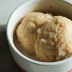 Close up of two scoops of lychee sorbet in a cup.