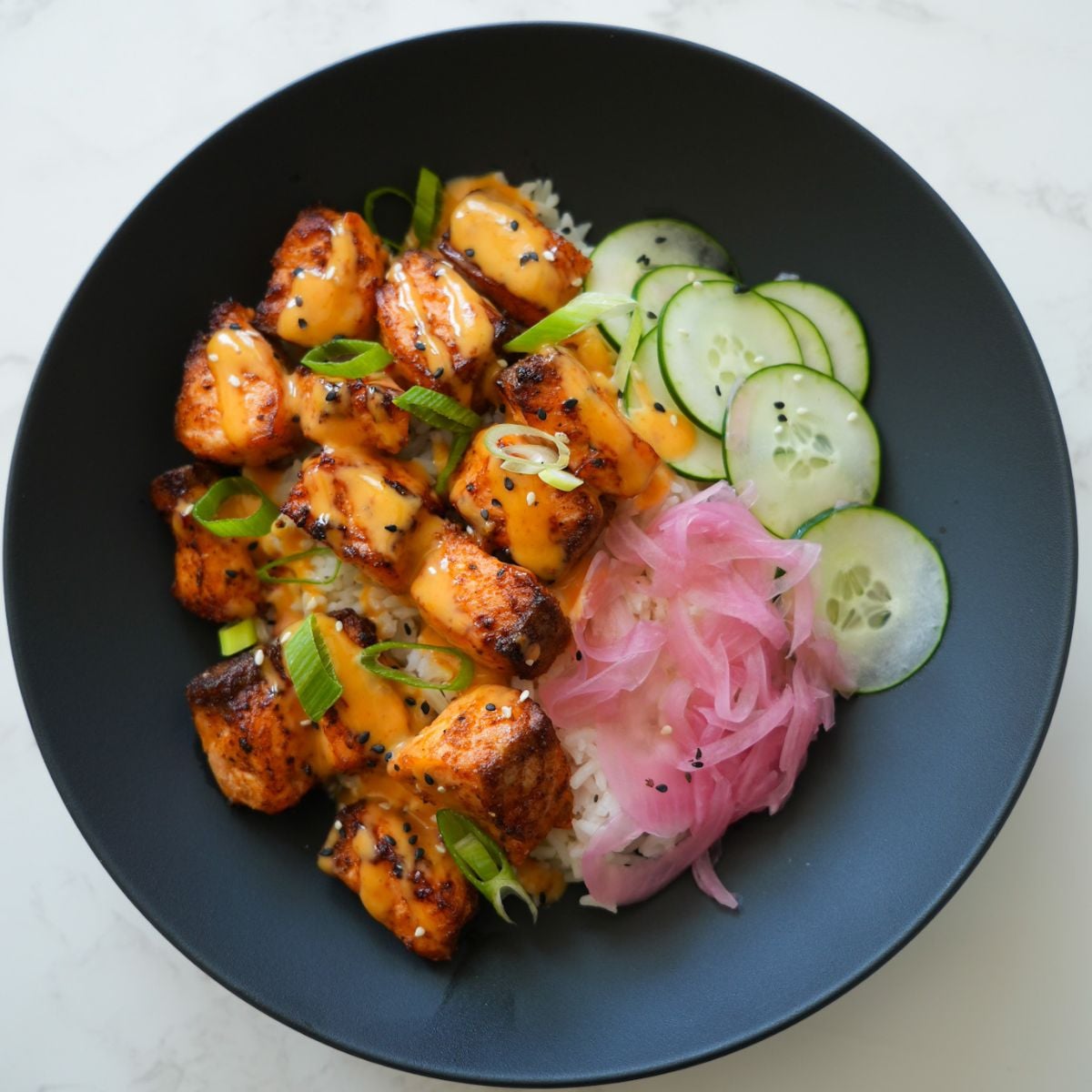 Crispy air-fried Bang Bang Salmon Bites drizzled with spicy-sweet bang bang sauce.