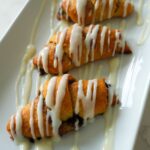 Golden cinnamon crescent rolls drizzled with a creamy glaze.
