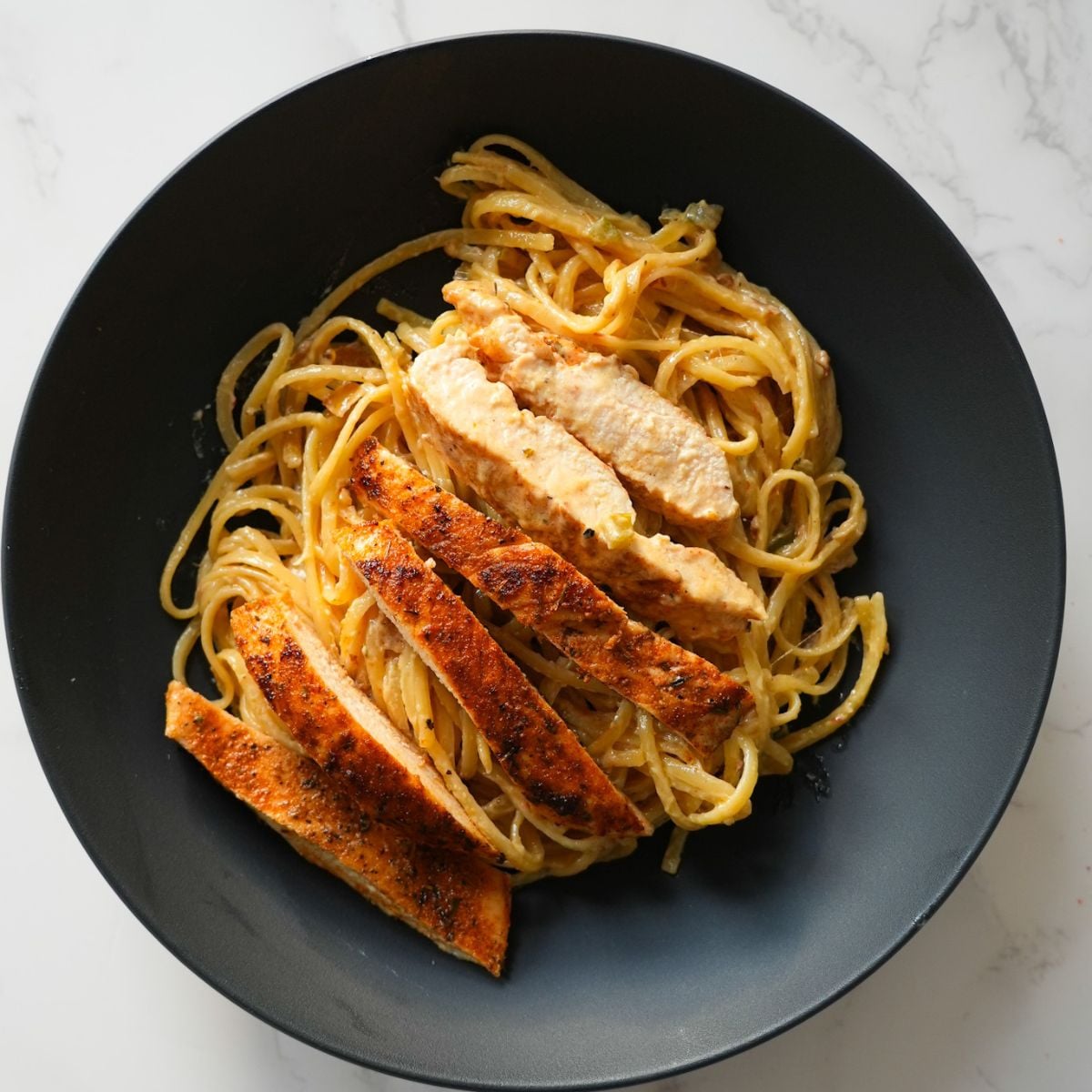 Creamy Cajun chicken pasta with sautéed veggies, seasoned chicken, and a rich, spicy sauce
