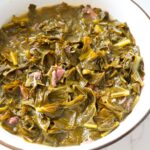 Tender soul food collard greens with smoked meat and savory broth.