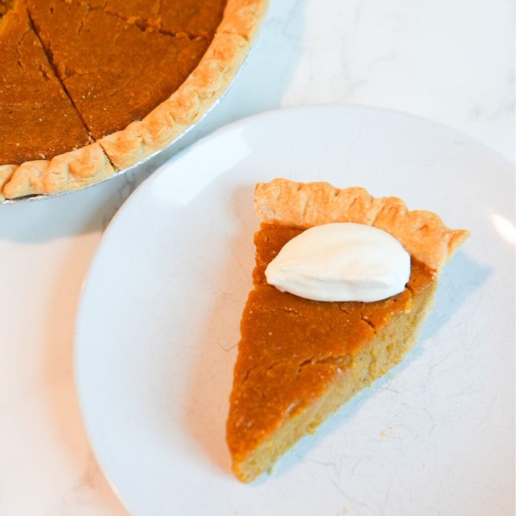 Southern sweet potato pie with a golden crust and whipped cream perfect for the holidays.