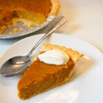 Southern sweet potato pie with a golden crust and whipped cream perfect for the holidays.