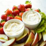 Creamy fruit dip with marshmallow fluff and cream cheese, served with fresh fruit slices.