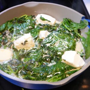 Cream cheese in a pan with spinach.