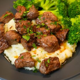 Juicy garlic butter steak bites over mashed potatoes.