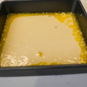 Peach cobbler ingredients in a pan before baking.