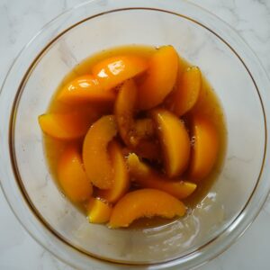 Peaches in heavy syrup for peach cobbler in a bowl