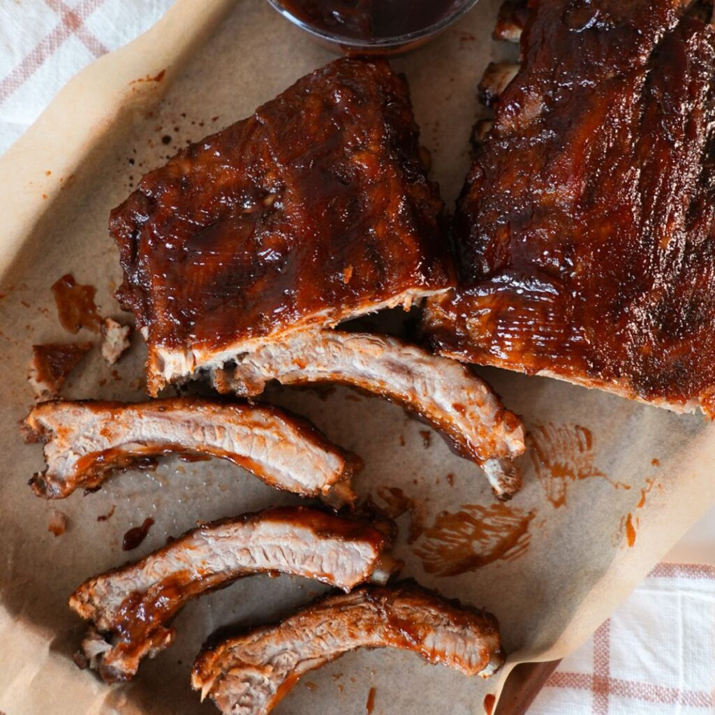 Juicy oven baked ribs brushed with BBQ sauce and broiled until caramelized.