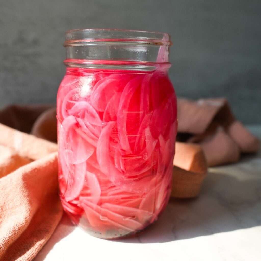 Pickled red onions in a jar.