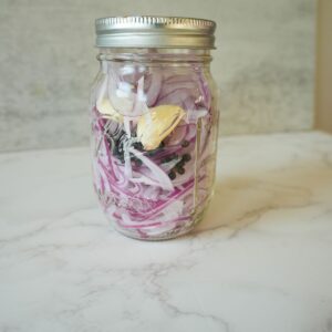 Red onions in a jar with garlic & peppercorns.
