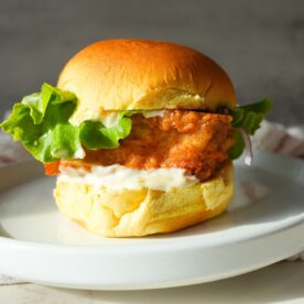 Golden fried fish filet on a potato bun, topped with creamy tartar sauce.