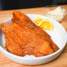 Golden crispy fried catfish on a plate.