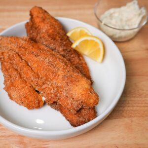 Golden crispy fried catfish on a plate.