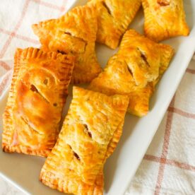 Golden brown puff pastry apple hand pies with flakey layers and spiced apple filling.
