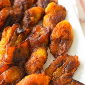 Golden brown fried plantains with crispy edges on a plate.