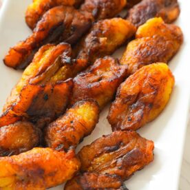 Golden brown fried plantains with crispy edges on a plate.