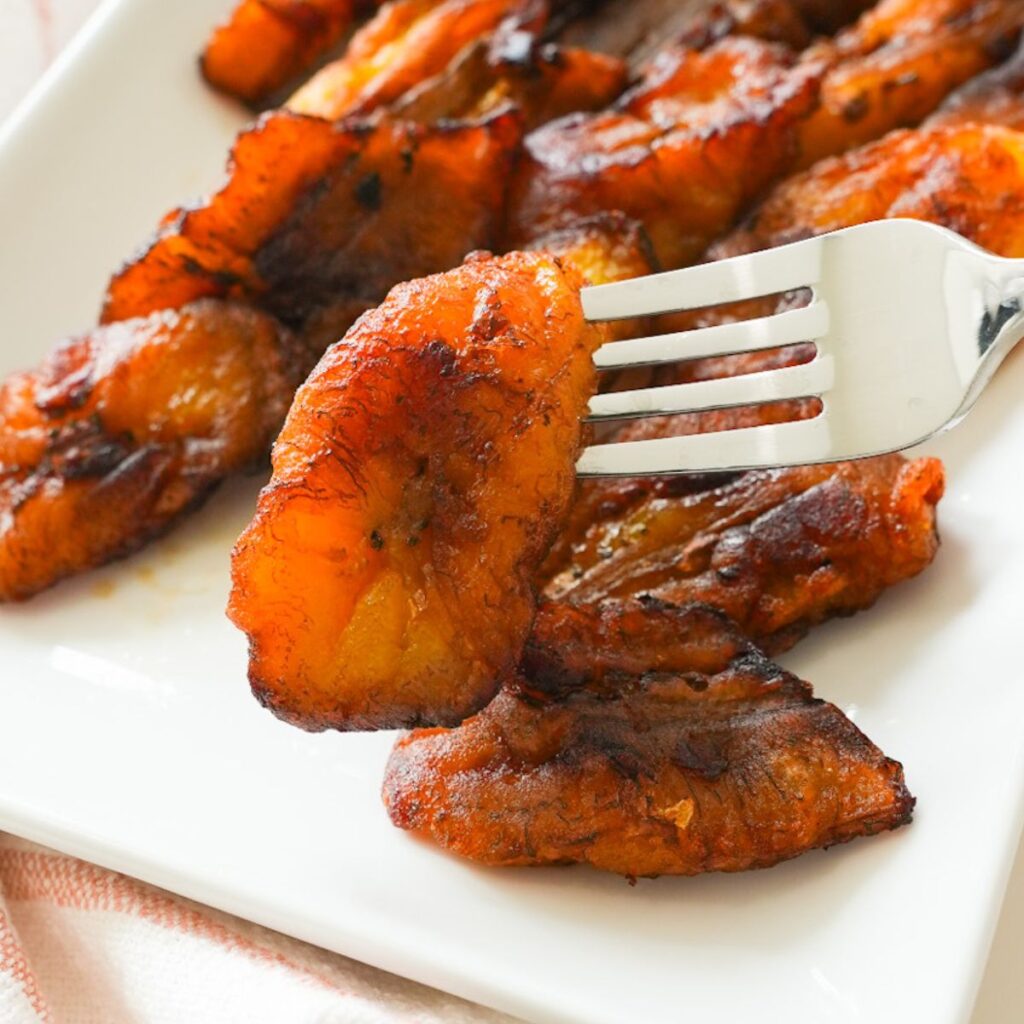 Close up of fried sweet plantain on a fork.