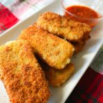 Mozzarella sticks on a white plate.