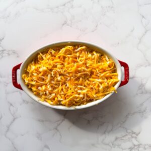 Macaroni in a baking dish covered with cheese.