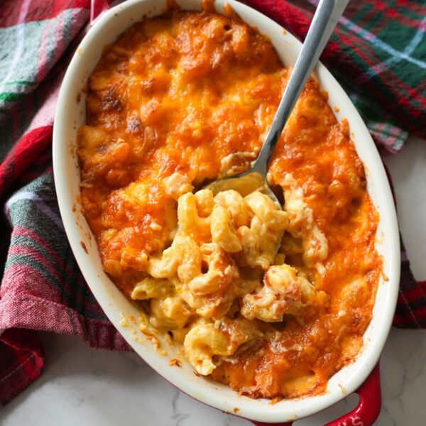 Baked macaroni and cheese in a baking dish with a spoon.