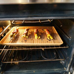 Bacon wrapped asparagus on a baking sheet in the oven.