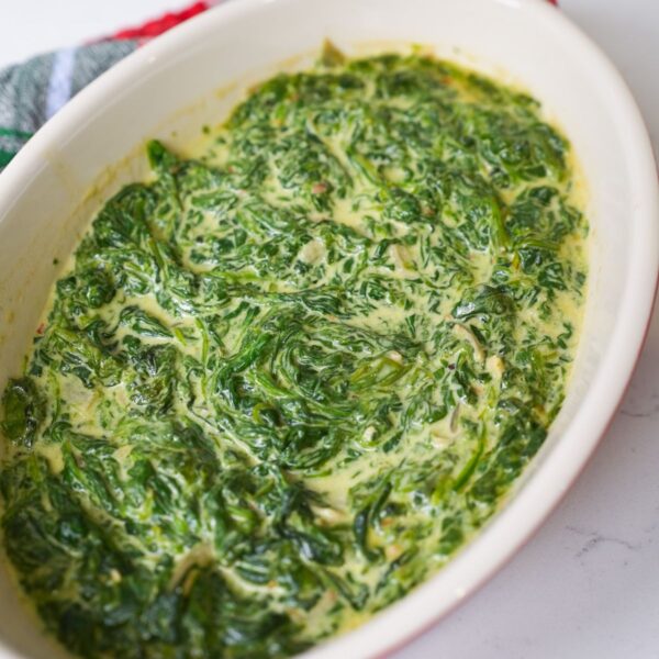 Creamed spinach in a baking dish with melted cheese, garlic, shallots and a rich creamy sauce.