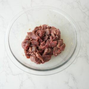 Cut up steak in a bowl.