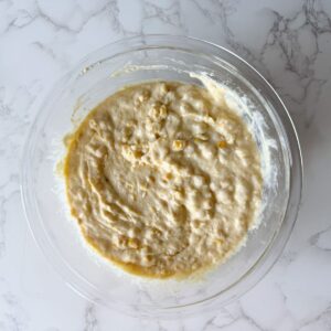 Corn casserole filling mixed in a bowl.