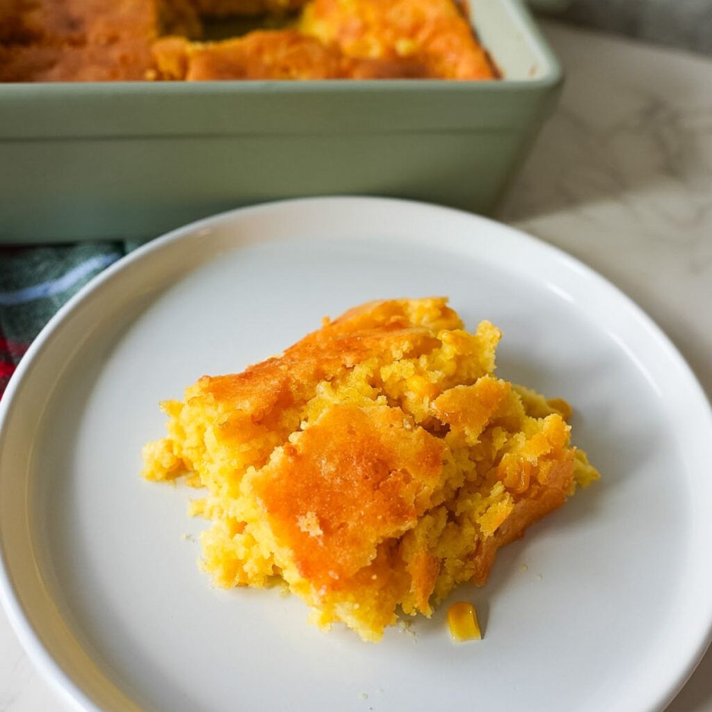A piece of corn casserole on a plate.
