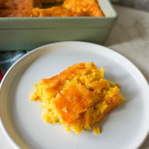 A piece of corn casserole on a plate.