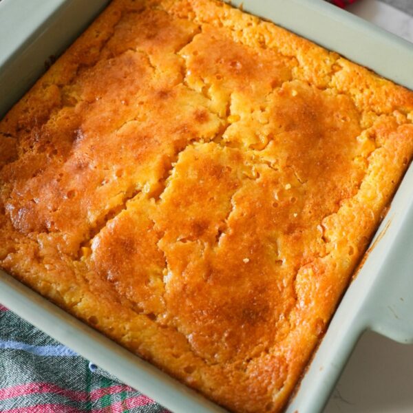 Corn casserole baked in a dish with a golden top and a soft, moist center.