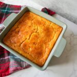 Corn casserole baked in a dish with a golden top and a soft, moist center.