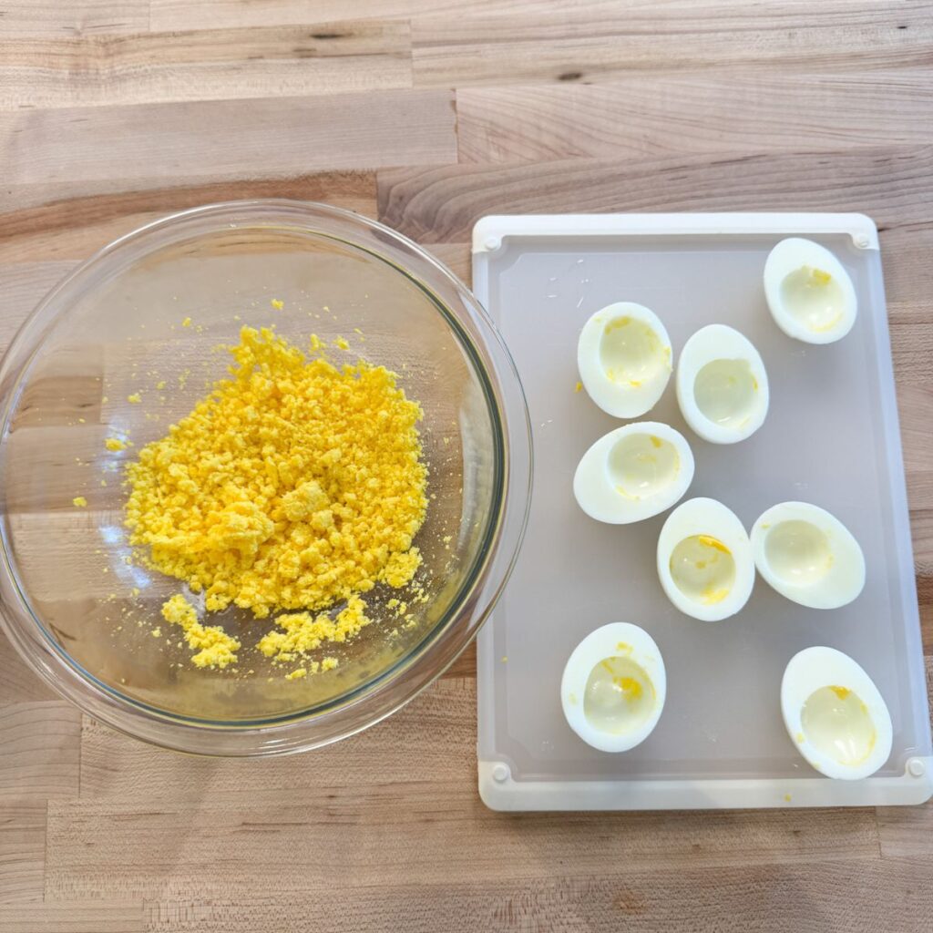 Egg yolks in a bowl with boiled egg whites on the side.