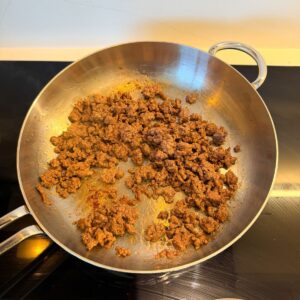 Ground beef browned in a skillet.