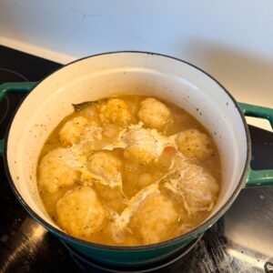 Dumplings and heavy cream in a pot.