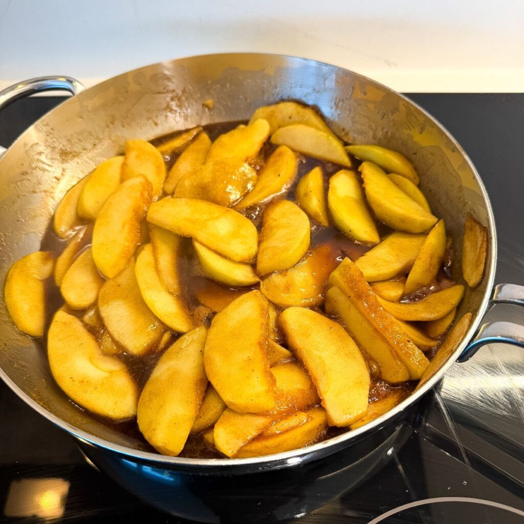 Southern fried apples in a skillet, being cooked.