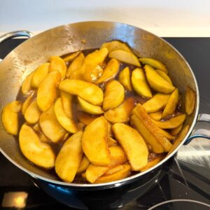Southern fried apples in a skillet, being cooked.