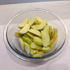 Apples sliced and cored in a bowl.