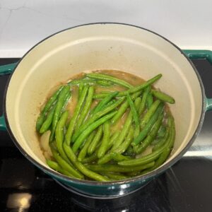 Green beans simmering in a dutch oven.
