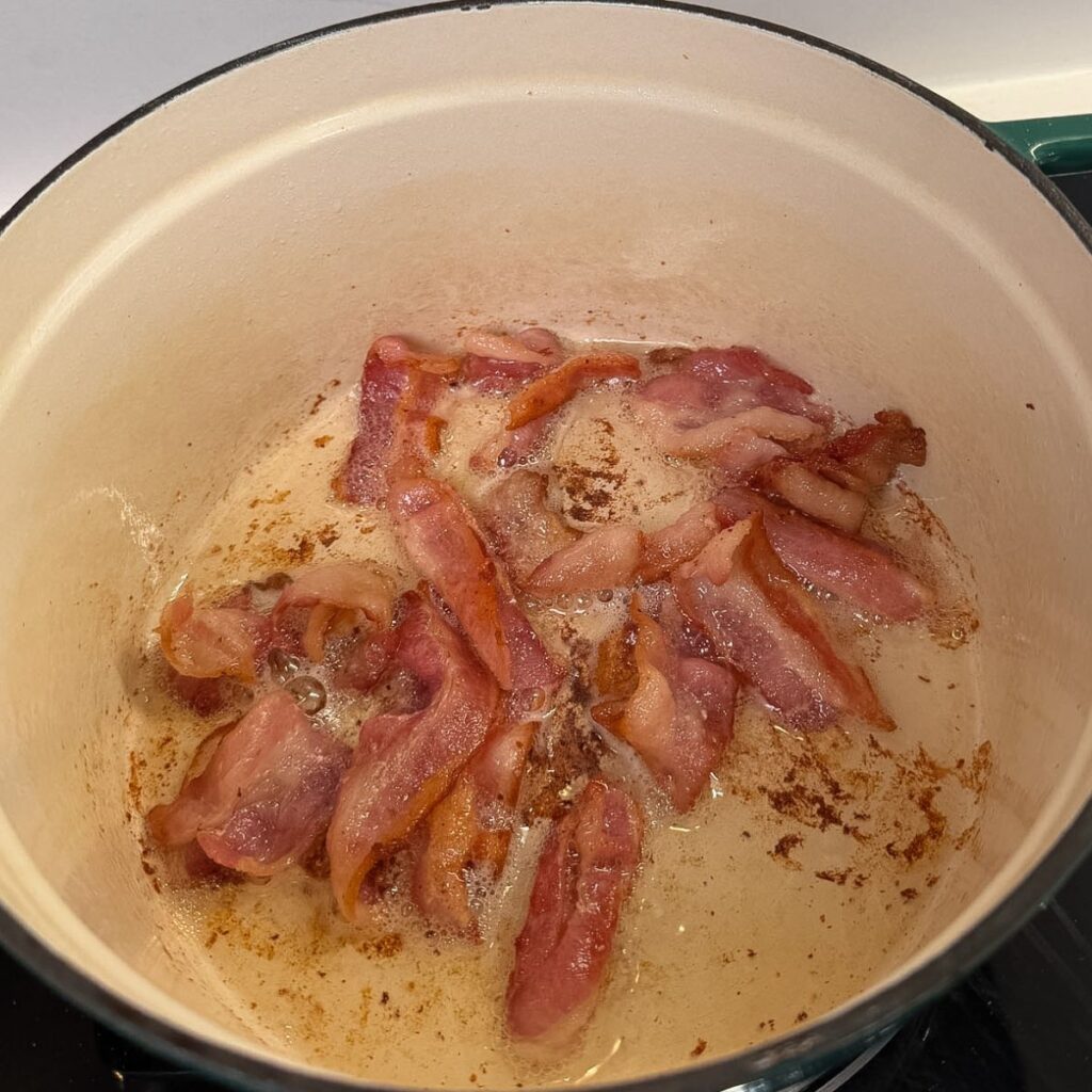Bacon cooking in a dutch oven.
