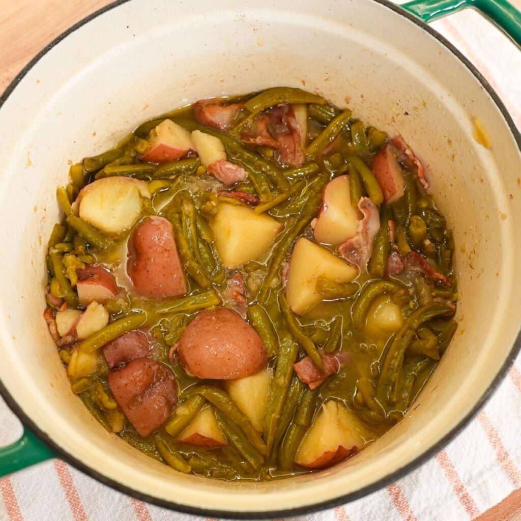 Southern green beans and red potatoes cooked with bacon in a pot with a light savory broth.