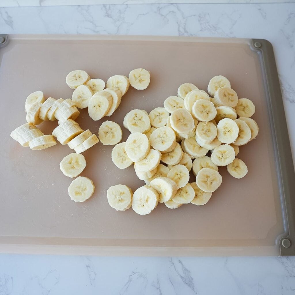 Bananas sliced on a cutting board.