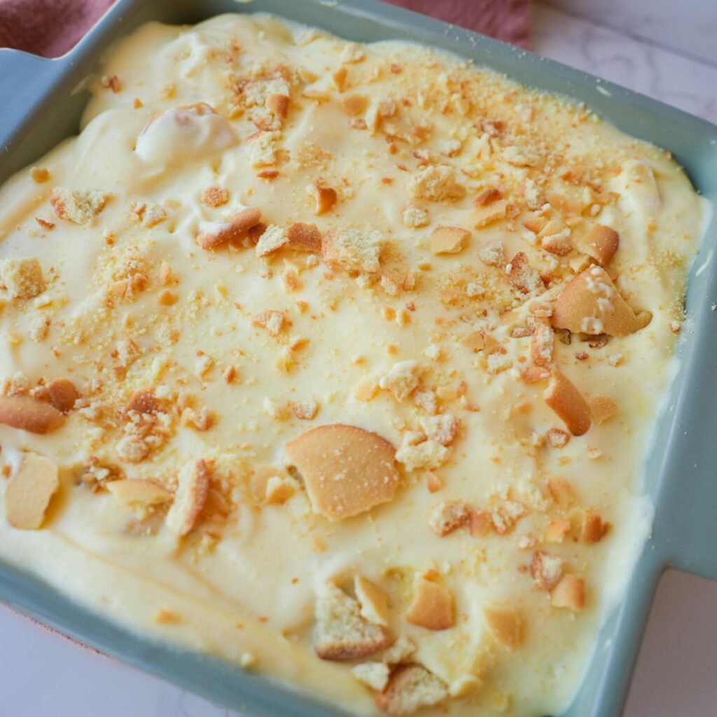 Banana pudding layered with sliced bananas, vanilla wafers, creamy pudding, and crushed wafers on top.