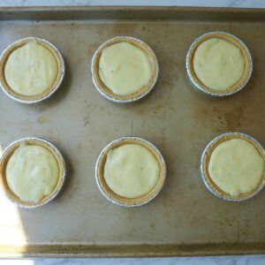 Mini key lime pies on a baking tray before baking.
