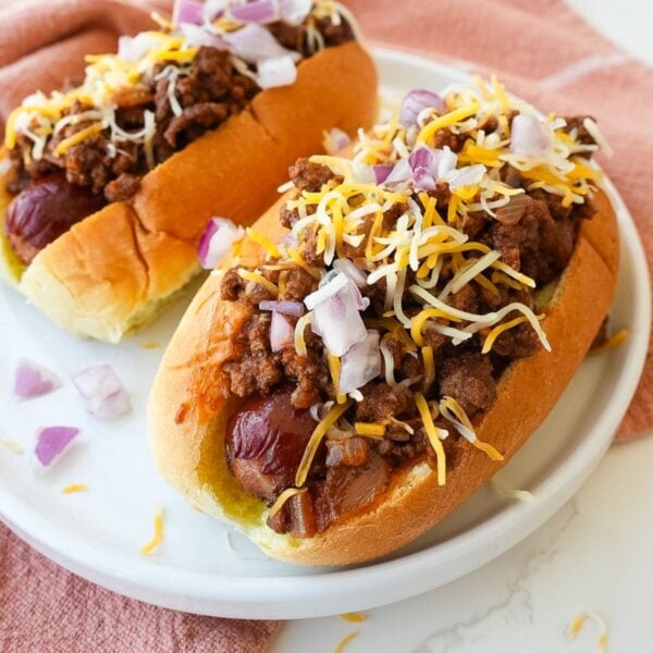 Hot dog topped with homemade chili, shredded cheese, and diced onions.